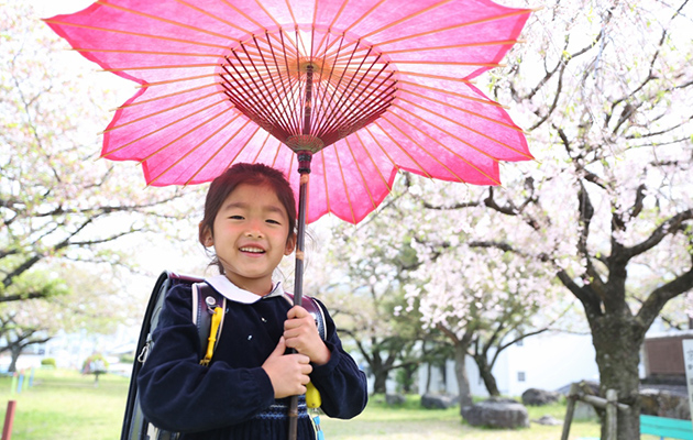 桜和傘をさしての記念撮影